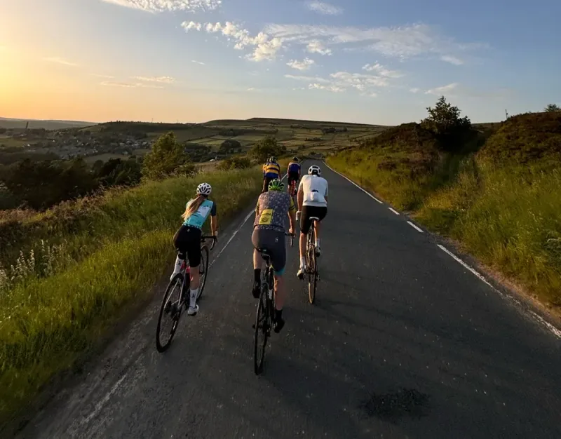 Halifax Imps riders on a moorland road under a big evening sky