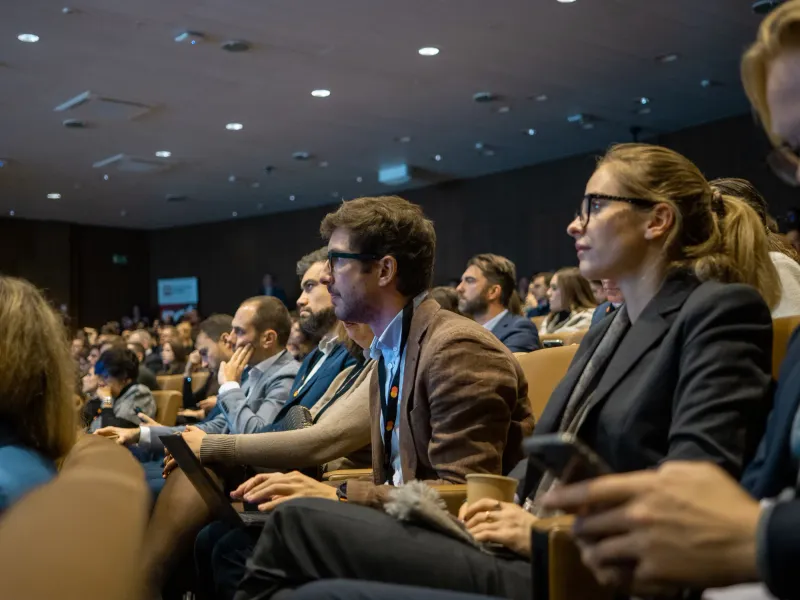The audience at a Dagorà summit in a darkened auditorium