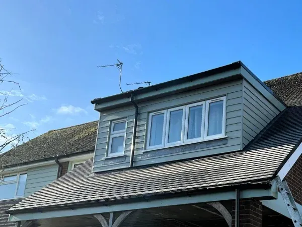 A finished house extension with a slate roof and new dormer window